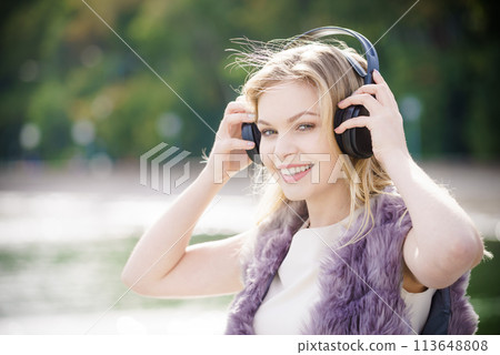 Happy woman wearing headphones outdoor Happy woman wearing headphones outdoor 113648808
