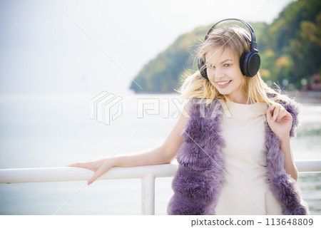 Happy woman wearing headphones outdoor Happy woman wearing headphones outdoor 113648809