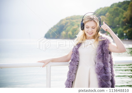 Happy woman wearing headphones outdoor Happy woman wearing headphones outdoor 113648810