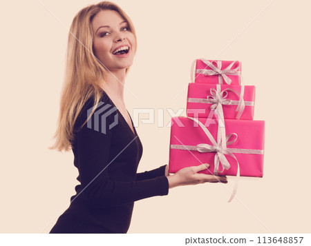 Girl holding stack of pink gift boxes Girl holding stack of pink gift boxes 113648857