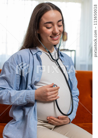Happy pregnant young woman using stethoscope listening to baby heartbeat unborn child vital signs Happy pregnant young woman using stethoscope listening to baby heartbeat unborn child vital signs 113650018