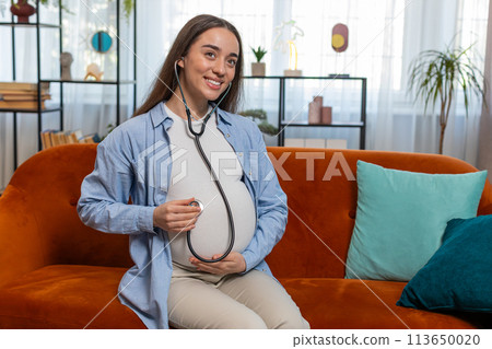Happy pregnant young woman using stethoscope listening to baby heartbeat unborn child vital signs Happy pregnant young woman using stethoscope listening to baby heartbeat unborn child vital signs 113650020