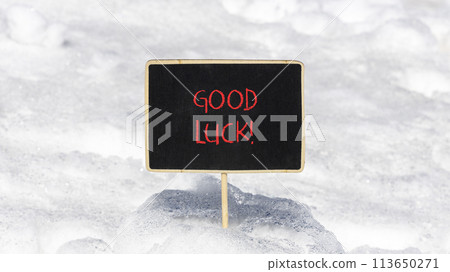 Good luck symbol. Concept words Good luck on beautiful black chalk blackboard. Beautiful white snow background. White snow. Business, motivational good luck concept. Copy space. 113650271