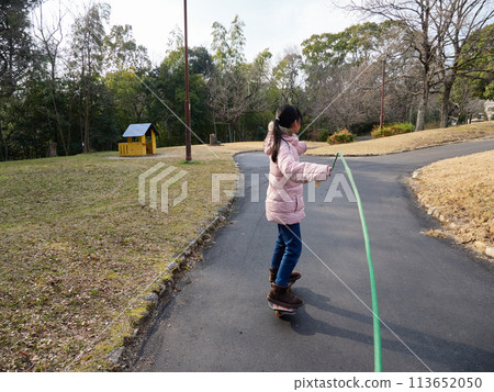小學生在冬季公園玩腳輪板 113652050