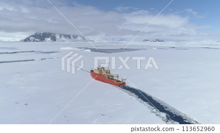 Antarctica Icebreaker Boat Break Ice Aerial Zoom in View. Laurence M. Gould Research Boat Float Through Thin Southern Ocean Frozen Surface at Packice Top Flight Drone Antarctica Icebreaker Boat Break Ice Aerial Zoom in View. Laurence M. Gould Research Boat Float Through Thin Southern Ocean Frozen Surface at Packice Top Flight Drone 113652960