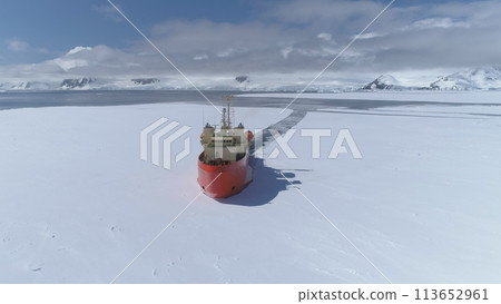 Antarctica Icebreaker Vessel Front Aerial View. Laurence M. Gould Research Boat Break Through Southern Ocean Glacier at Frozen Polar Coast Top Tracking Drone 113652961