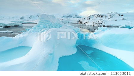 Glacier melting in Antarctica. Global warming. Climate change. Iceberg blue water cavity floating in cold water. Ice drift in polar ocean. Pristine Antarctic landscapes. Close up drone shot 113653011