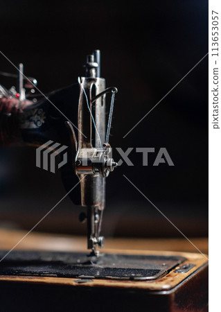 Old sewing machine stands on the table at home ready to work and sew. 113653057
