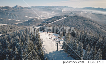 Ski slope, escalator at snow mountain aerial. Winter nature landscape. Pine forest. Extreme sport and recreation. Tourist landmark. Vacation at Carpathians mounts, Bukovel Resort, Ukraine, Europe Ski slope, escalator at snow mountain aerial. Winter nature landscape. Pine forest. Extreme sport and recreation. Tourist landmark. Vacation at Carpathians mounts, Bukovel Resort, Ukraine, Europe 113654710