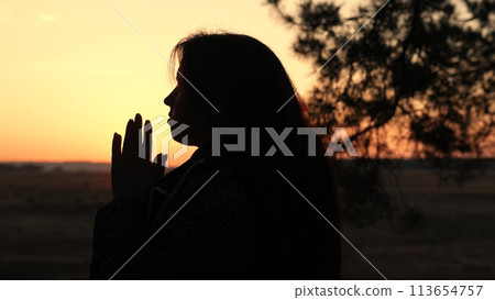 girl woman praying at sunset, hand sunset faith pain, asking heaven for help, spiritual sunset meditation, serene prayer moment, dusk reflection solitude, sunset prayer tranquility, peaceful evening 113654757