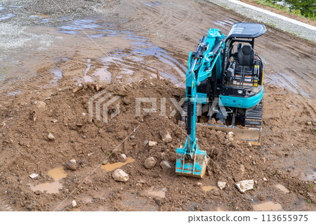 A photo of a small excavation construction machine. Image of a shovel car and civil engineering work. A photo of a small excavation construction machine. Image of a shovel car and civil engineering work. 113655975