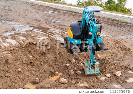 A photo of a small excavation construction machine. Image of a shovel car and civil engineering work. A photo of a small excavation construction machine. Image of a shovel car and civil engineering work. 113655976