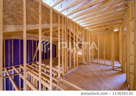 New unfinished residential home under construction with framing made of wood supporting beam New unfinished residential home under construction with framing made of wood supporting beam 113656130