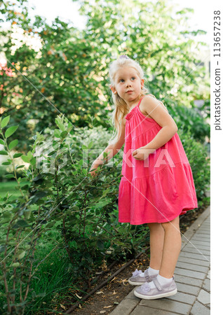 Child girl walks and have fun outdoor with cochlear implant on the head. Hearing aid and treatment concept. Copy space vertical. Inclusion Child girl walks and have fun outdoor with cochlear implant on the head. Hearing aid and treatment concept. Copy space vertical. Inclusion 113657238