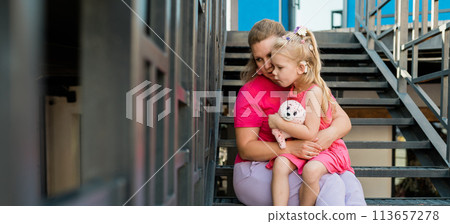 Banner blonde little girl with cochlear implant playing with her mother outdoor. Hear impairment deaf and health concept. Diversity and inclusion. Copy space Banner blonde little girl with cochlear implant playing with her mother outdoor. Hear impairment deaf and health concept. Diversity and inclusion. Copy space 113657278