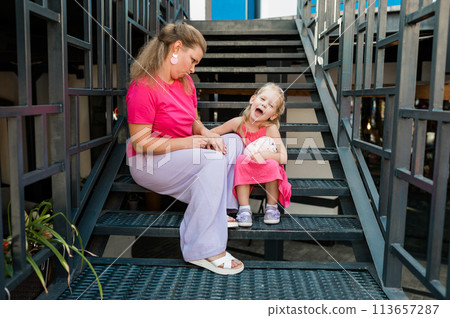 Blonde little girl with cochlear implant playing with her mother outdoor. Hear impairment deaf and health concept. Diversity and inclusion. Copy space Blonde little girl with cochlear implant playing with her mother outdoor. Hear impairment deaf and health concept. Diversity and inclusion. Copy space 113657287