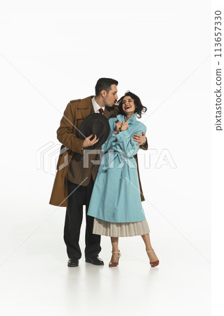 Beautiful couple wearing retro-styled clothes walking together, going on a date isolated on white background. Happy smiling woman and man kissing her cheek Beautiful couple wearing retro-styled clothes walking together, going on a date isolated on white background. Happy smiling woman and man kissing her cheek 113657330