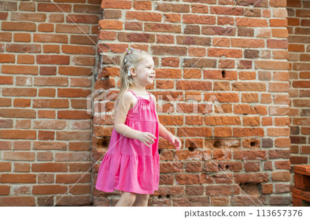 Child girl walks and have fun outdoor with cochlear implant on the head. Hearing aid and treatment concept. Copy space vertical. Inclusion 113657376
