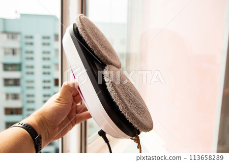 Connecting a vacuum window cleaner robot to a balcony frame, close-up 113658289