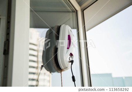 Automatic vacuum robot window cleaner washes glass in the apartment, balcony frame, 113658292