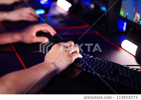 Skill Close up player's hands use professional gaming mouse and PC keyboard with RGB lighting, mat. E-sport tournament with cyber team in computer club. Gamers play video game. Strategy shooter Skill Close up player's hands use professional gaming mouse and PC keyboard with RGB lighting, mat. E-sport tournament with cyber team in computer club. Gamers play video game. Strategy shooter 113658373