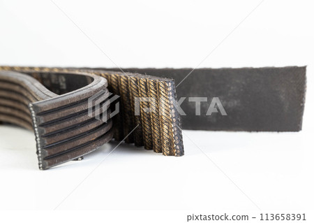 Torn timing belt and generator rivulet belt on a white background. Broken belts in the car, industry, close-up Torn timing belt and generator rivulet belt on a white background. Broken belts in the car, industry, close-up 113658391