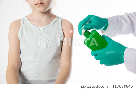 Doctor's hands with cotton wool and antiseptic treating the skin before vaccination against tetanus and viral hepatitis. Revaccination of children, hemophilus influenzae infection Doctor's hands with cotton wool and antiseptic treating the skin before vaccination against tetanus and viral hepatitis. Revaccination of children, hemophilus influenzae infection 113658649
