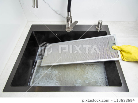 kitchen hood filters for sinks with a modern oxygen cleaner for grease and stains. Washing and cleaning the kitchen, close-up. Chemical reaction kitchen hood filters for sinks with a modern oxygen cleaner for grease and stains. Washing and cleaning the kitchen, close-up. Chemical reaction 113658694