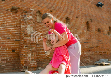 Child girl with cochlear implant with her mother spend time outdoor. Hear impairment and deaf community concept. Deaf and health concept. Diversity and inclusion. Copy space 113659586