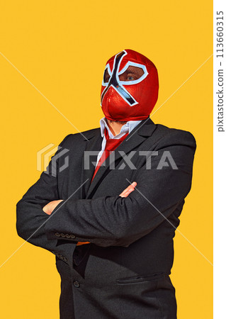 Portrait of confident man in wrestler attire with mask in official attire crossed hand on breast against yellow studio background. Portrait of confident man in wrestler attire with mask in official attire crossed hand on breast against yellow studio background. 113660315