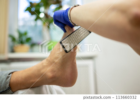 concept of male pedicure, cosmetologist makes classic pedicure for an elderly male client. concept of male pedicure, cosmetologist makes classic pedicure for an elderly male client. 113660332