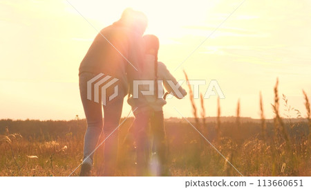 Woman teaching girl to ride bike, silhouettes at sunrise. Exciting activities with family, older, mom and daughter spend time together. Playful interesting form of learning to ride bike. Fun childhood 113660651