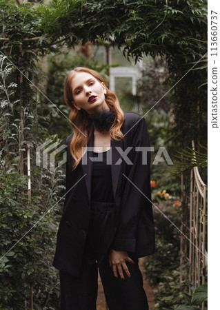 A woman walking through a greenhouse. A woman walking through a greenhouse. 113660737