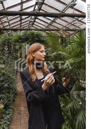 Caucasian woman using tablet in garden. 113660738