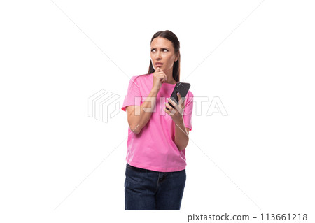 young smart good-looking woman with black hair dressed in a pink t-shirt holding a smartphone and 113661218