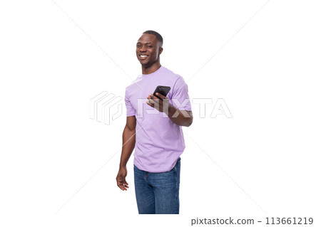 young handsome african man in lilac t-shirt doubts uses smartphone young handsome african man in lilac t-shirt doubts uses smartphone 113661219