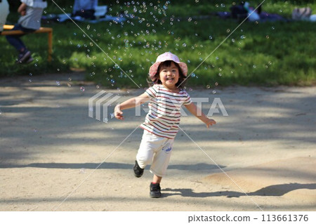 A girl playing with soap bubbles A girl playing with soap bubbles 113661376