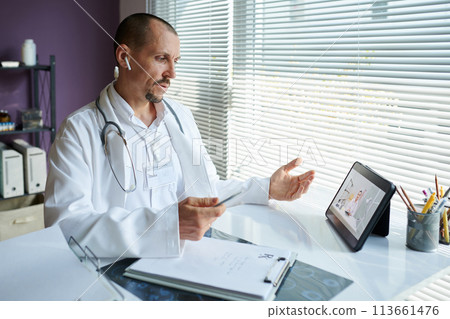 Physician calling colleague from another clinic to discuss prescription for patient 113661476