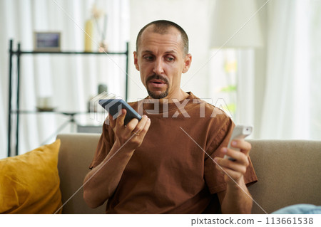 Sick man recording voice message for doctor after measuring body temperature Sick man recording voice message for doctor after measuring body temperature 113661538