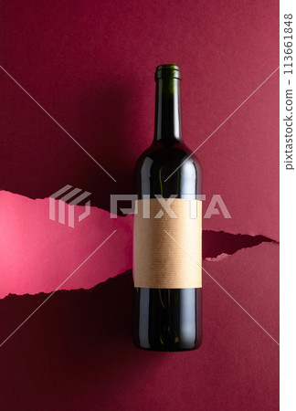 Bottle of red wine with old empty label on a dark red background. Bottle of red wine with old empty label on a dark red background. 113661848