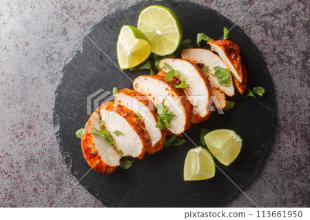 Chipotle chicken is smoky, spicy and a bit tangy from the lime juice closeup on a slate plate. Horizontal top view Chipotle chicken is smoky, spicy and a bit tangy from the lime juice closeup on a slate plate. Horizontal top view 113661950