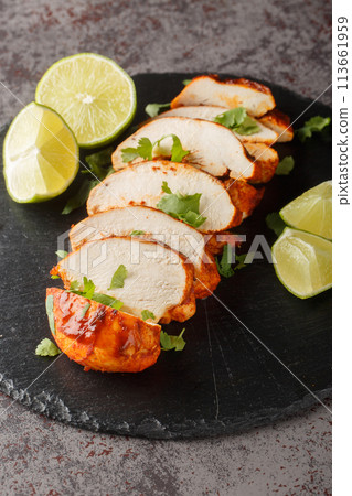 Fried chipotle chicken breast served with lime and cilantro close-up on a slate plate. Vertical Fried chipotle chicken breast served with lime and cilantro close-up on a slate plate. Vertical 113661959