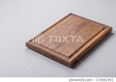 Empty wooden cutting board on gray textured concrete background Empty wooden cutting board on gray textured concrete background 113662361