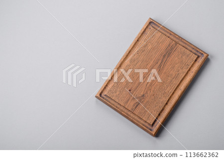Empty wooden cutting board on gray textured concrete background Empty wooden cutting board on gray textured concrete background 113662362