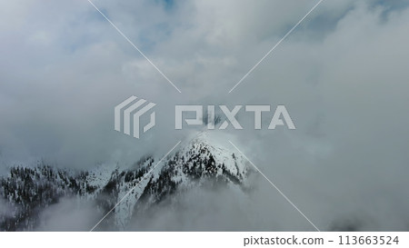 Aerial view of snowcapped mountains in clouds Aerial view of snowcapped mountains in clouds 113663524