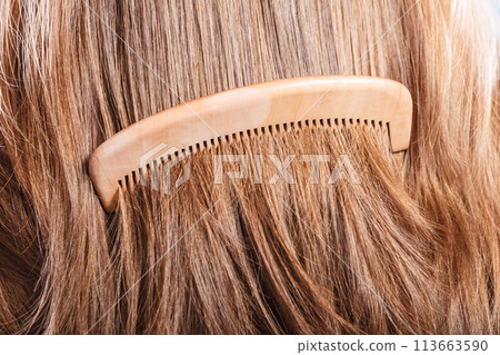 Straight brown hair with wooden comb closeup 113663590