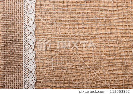 Lace ribbon on burlap cloth background Lace ribbon on burlap cloth background 113663592