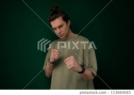 Man Standing in Front of Green Wall Man Standing in Front of Green Wall 113664083