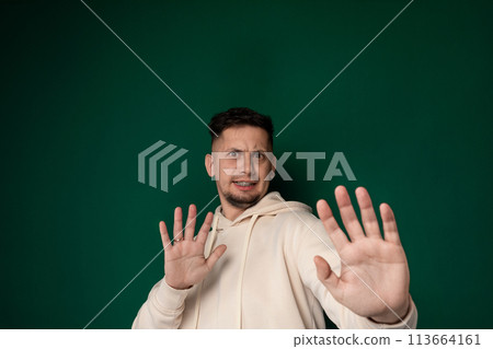 Man in Hoodie Holding Hands Up 113664161