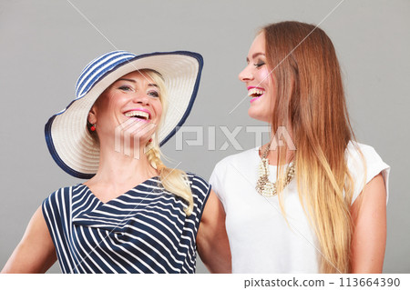 Fashionable mother and daughter posing together Fashionable mother and daughter posing together 113664390